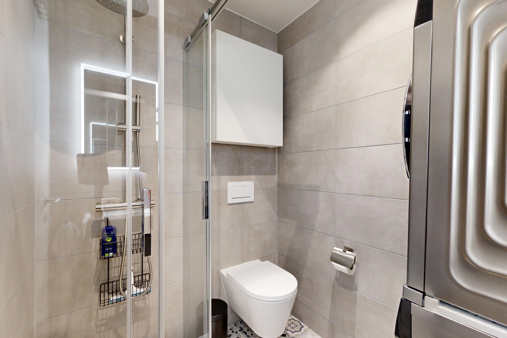 full bath featuring a stall shower, tile walls, and washer / clothes dryer