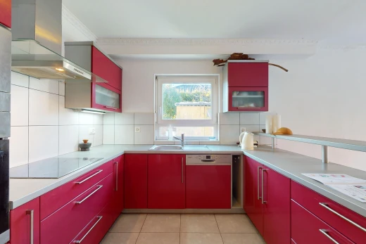 kitchen with wall chimney exhaust hood, dishwasher, black electric cooktop, and tasteful backsplash