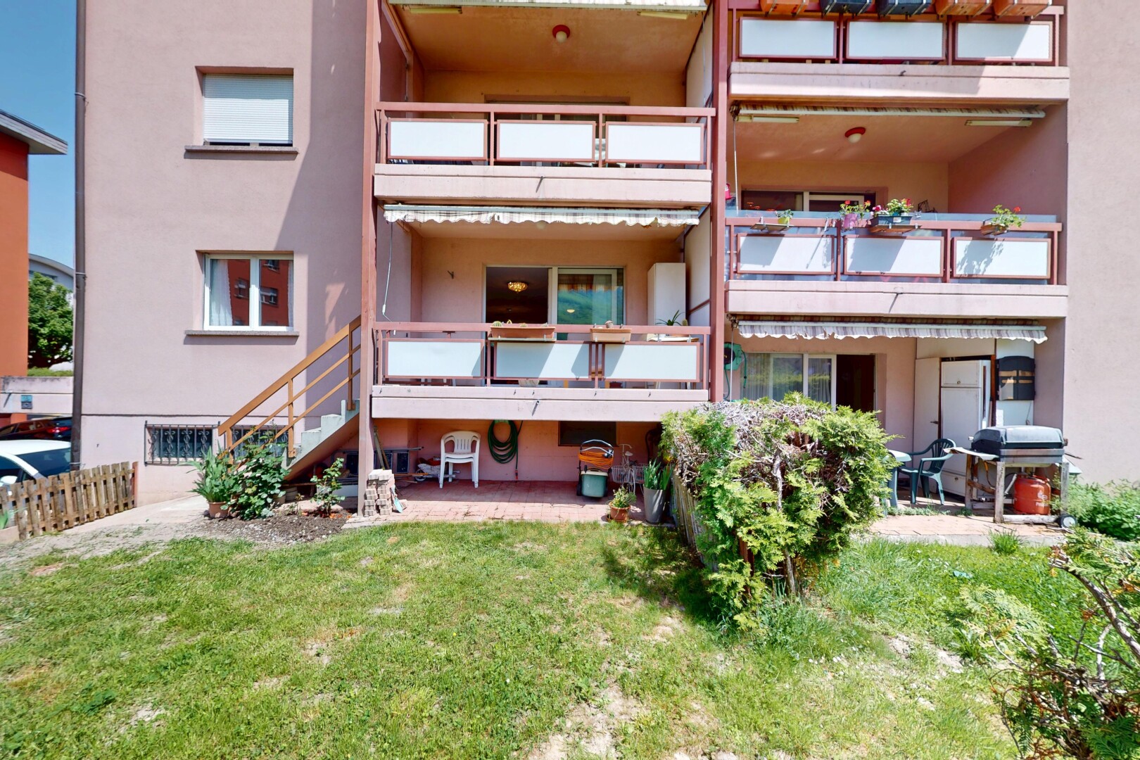 extérieur du bâtiment avec vue sur le complexe d'appartements, escaliers, et clôture