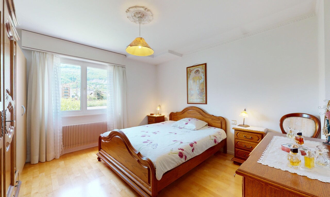 chambre avec cloison sèche, radiateur, sol en finition bois, et lumière naturelle