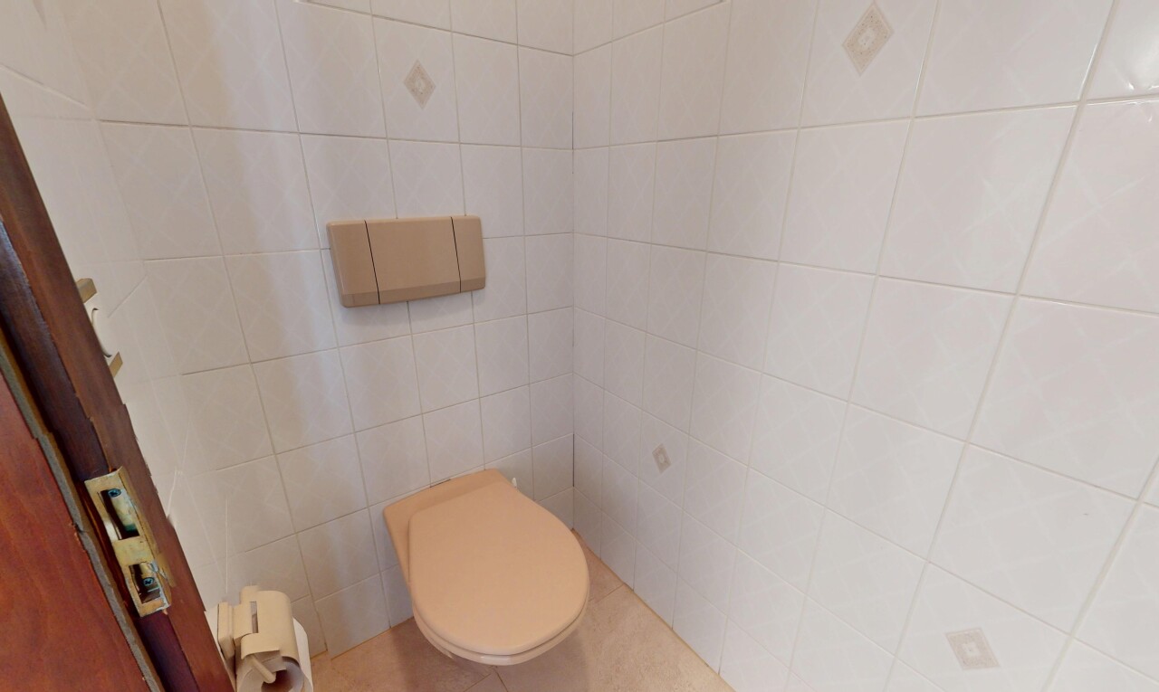 salle de bains avec mur en carrelage, radiateur, et toilette