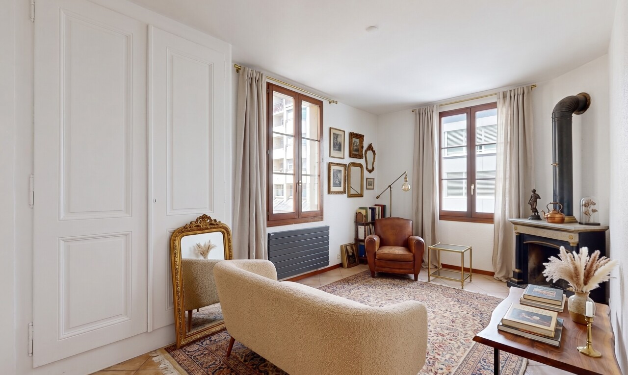 spare room featuring a wood stove, radiator, light tile patterned floors, and healthy amount of natural light