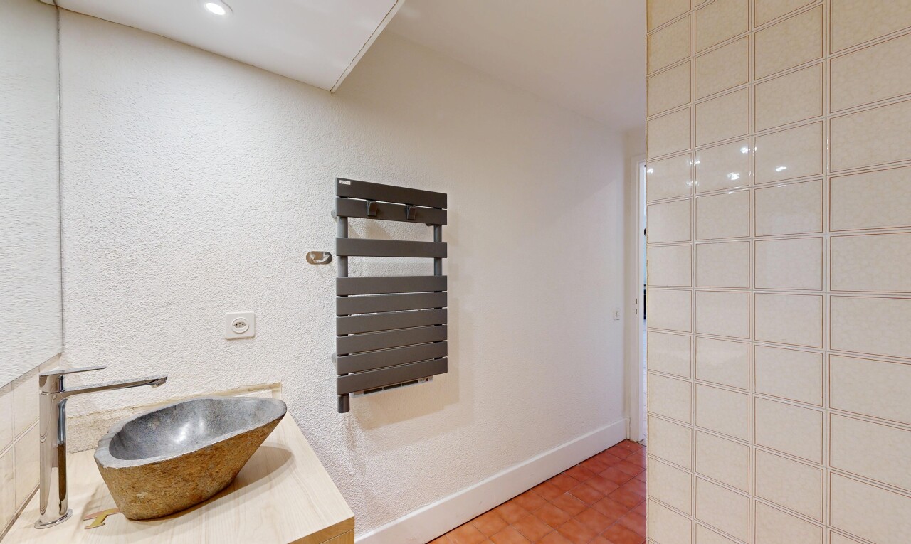 salle de bains avec chauffe-serviettes, évier, lavabo (ou coiffeuse selon le contexte), vinyl floor, et sol en vinyle