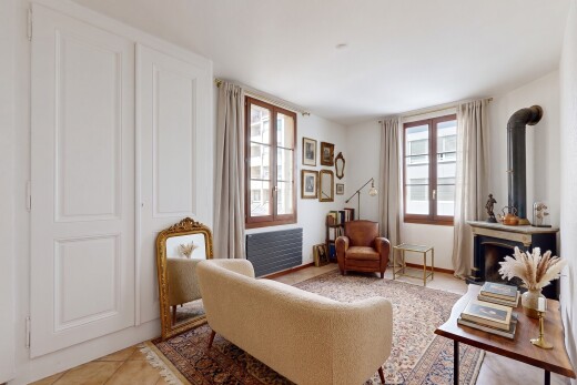 spare room featuring a wood stove, radiator, light tile patterned floors, and healthy amount of natural light