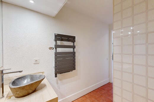 salle de bains avec chauffe-serviettes, évier, lavabo (ou coiffeuse selon le contexte), vinyl floor, et sol en vinyle