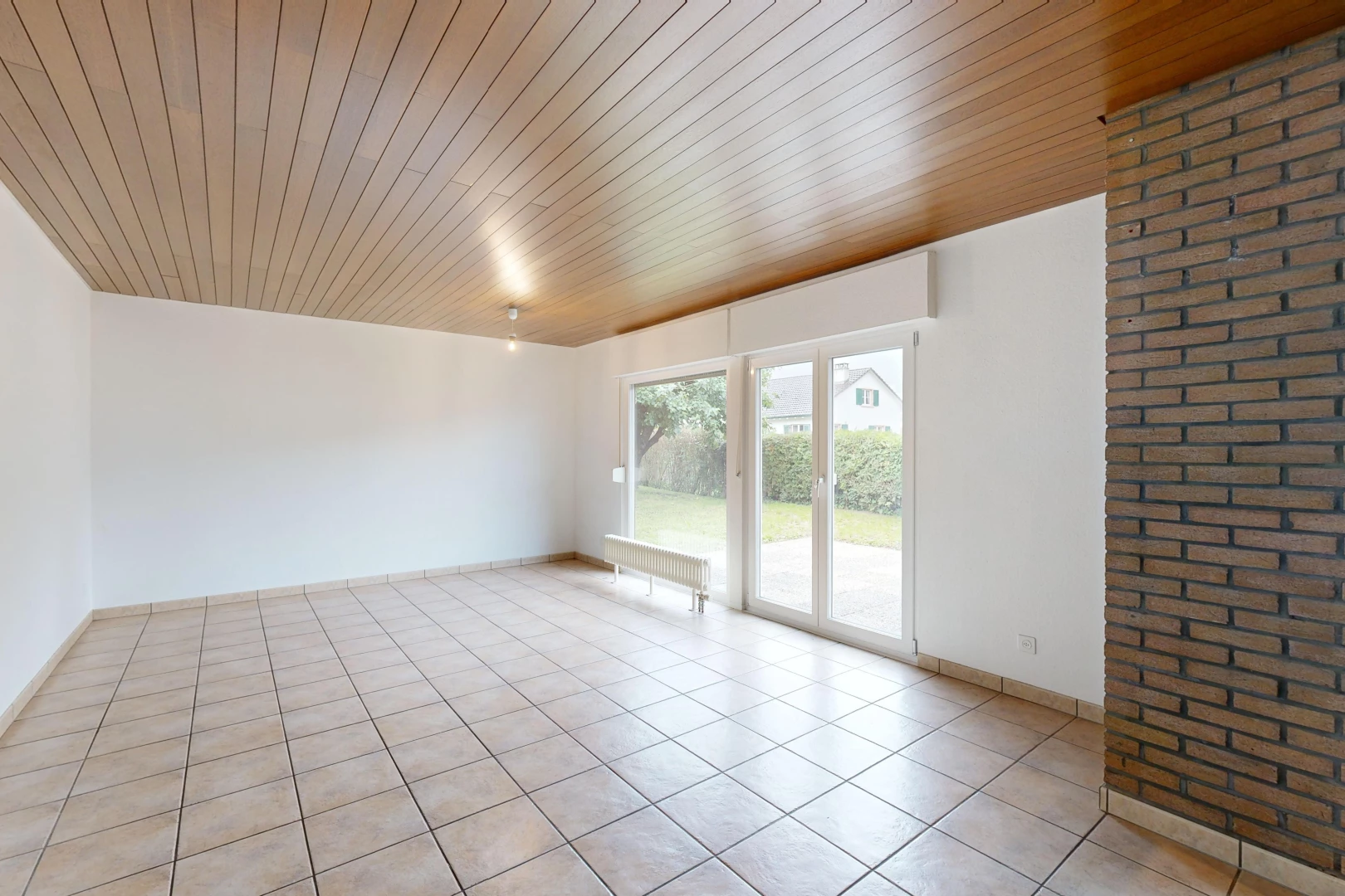 pièce vide avec carrelage, plafond de bois, et lumière naturelle
