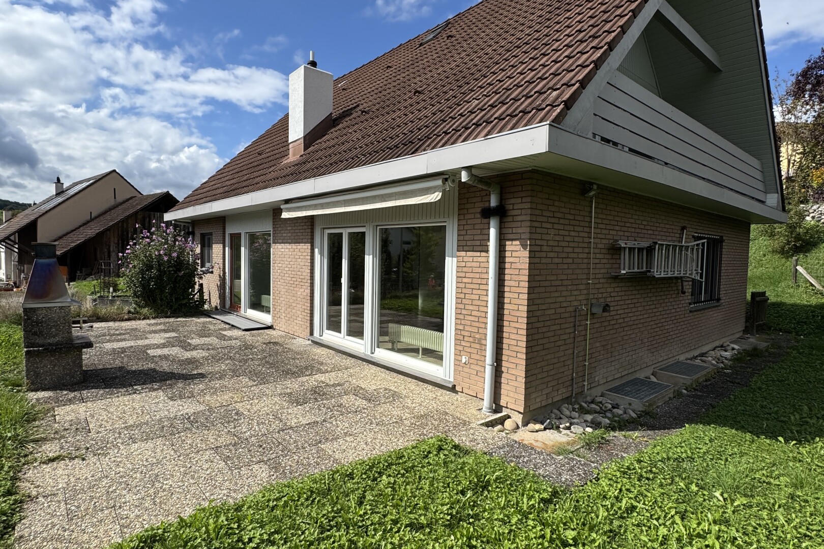 façade avec day time, bardage en brique, property visible, terrasse, et cheminée