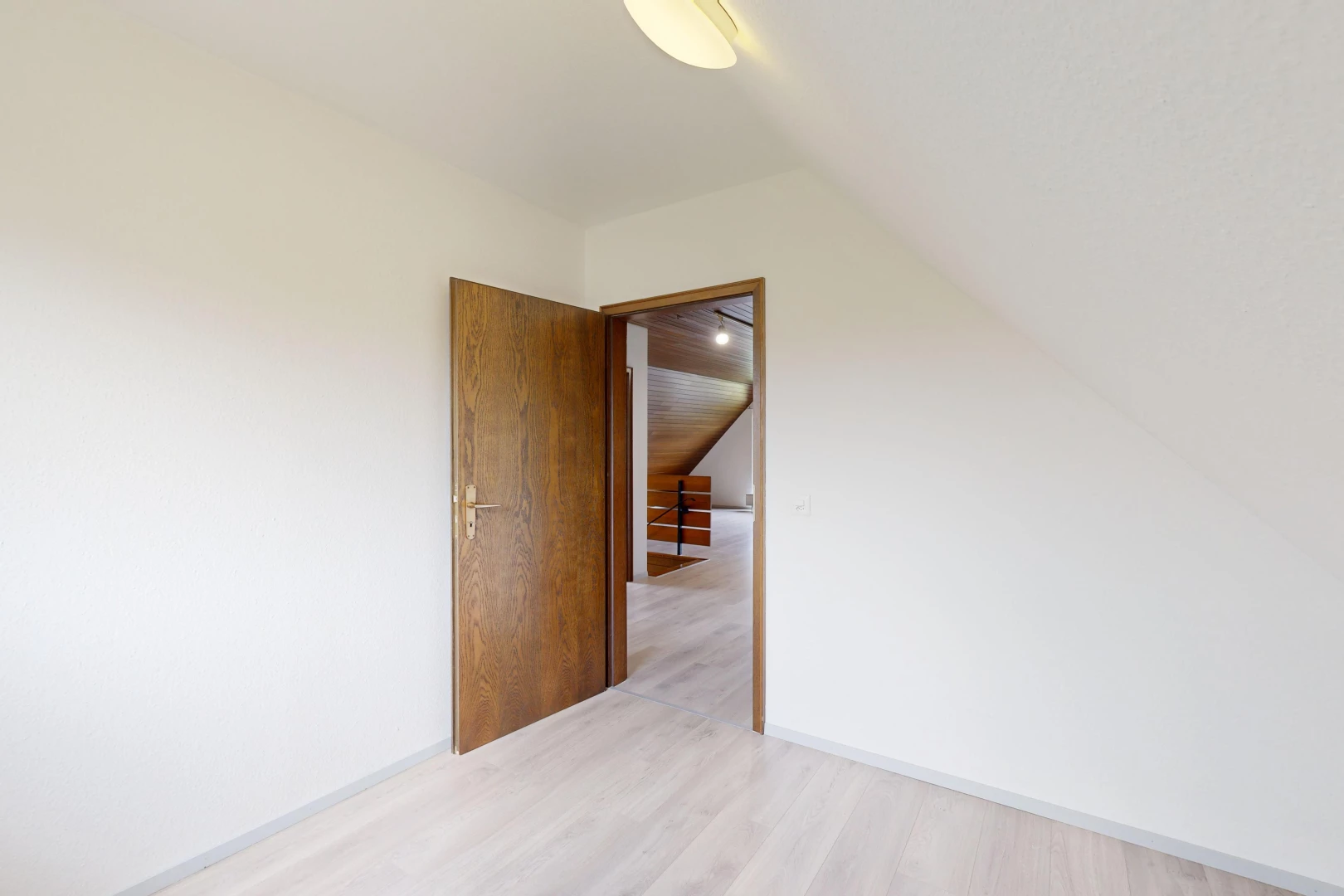 pièce vide avec plafond voûté et plancher de bois