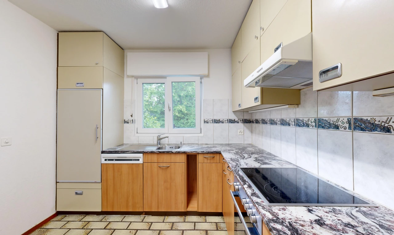 cuisine avec crédence, cuisinière, lumière naturelle, vasque, et hotte