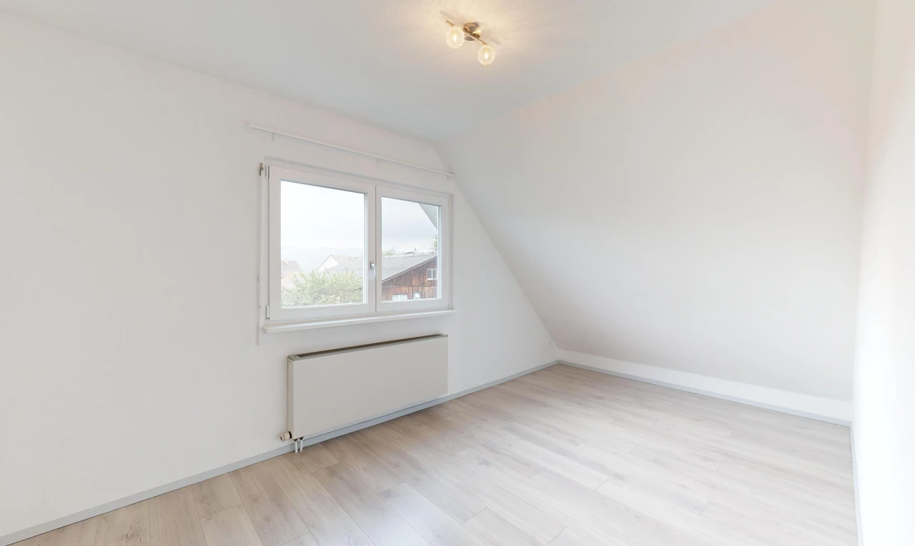 pièce vide avec plancher de bois, lumière naturelle, radiateur, plafond voûté, et plafond bas