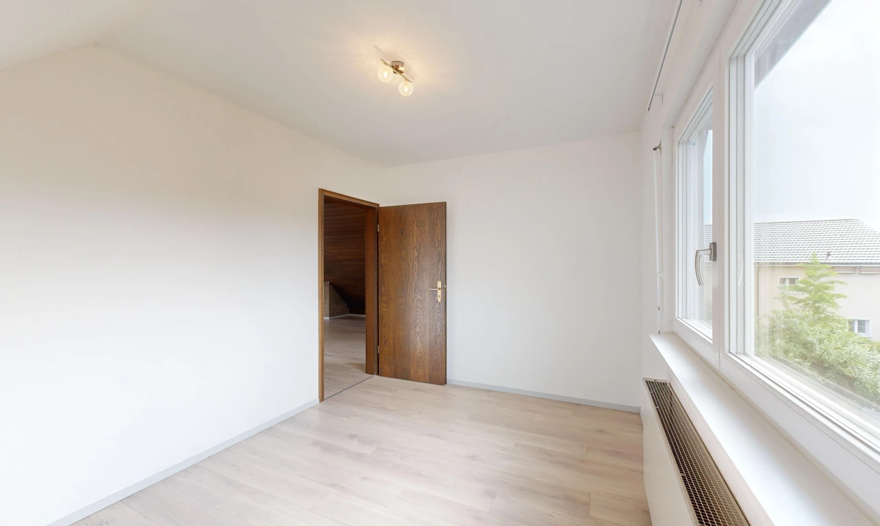 pièce vide avec radiateur, plancher de bois, et lumière naturelle