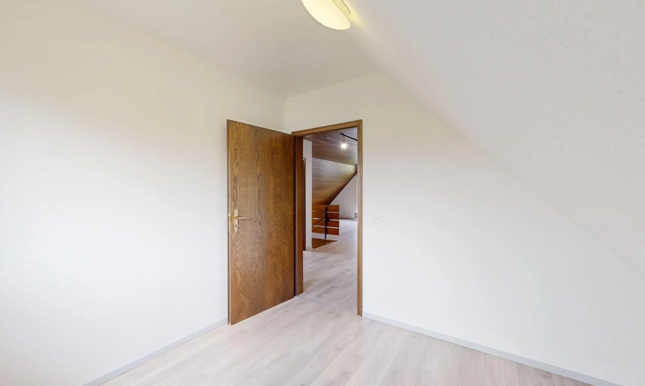 pièce vide avec plafond voûté et plancher de bois
