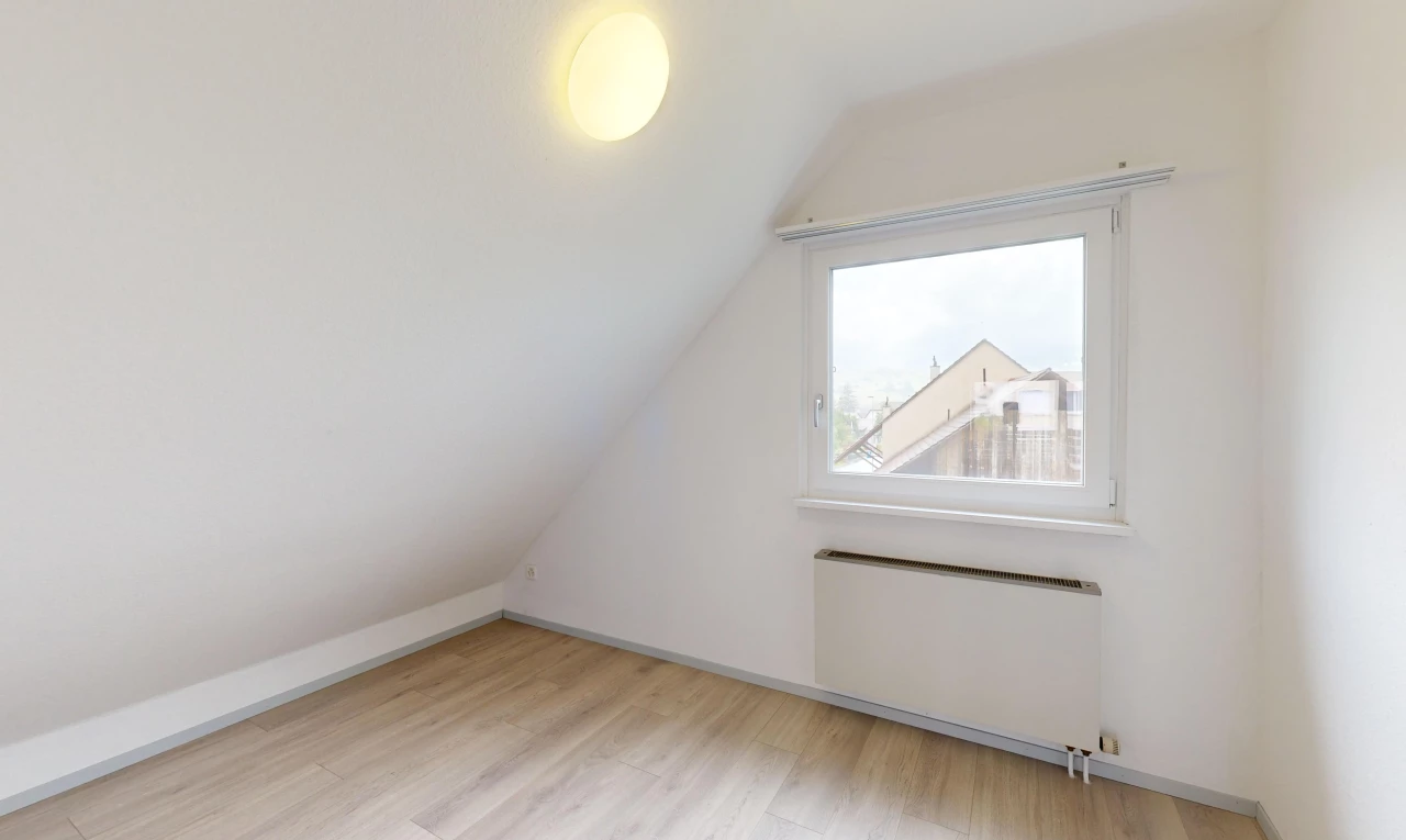 pièce vide avec plancher de bois, lumière naturelle, radiateur, plafond voûté, et plafond bas