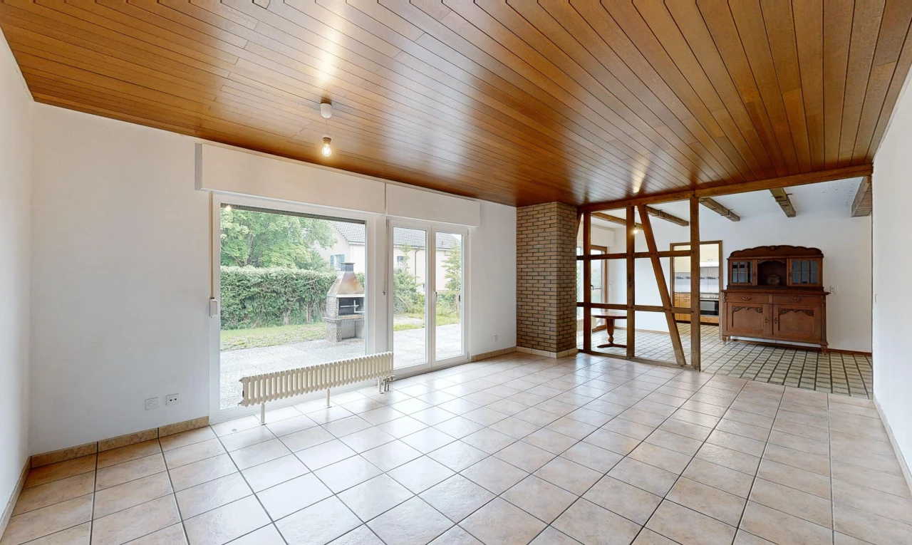 pièce vide avec carrelage, plafond de bois, mur en briques, et lumière naturelle