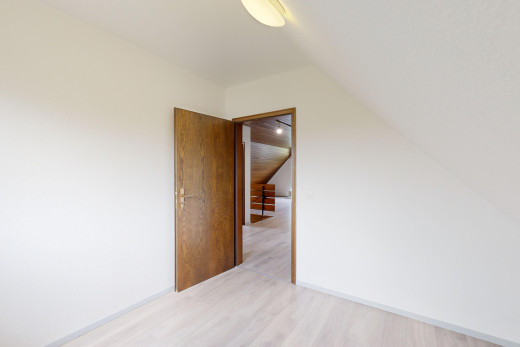 pièce vide avec plafond voûté et plancher de bois
