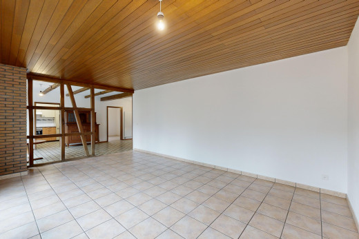 pièce vide avec plafond de bois, lumière naturelle, carrelage, et mur en briques