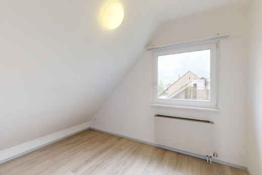pièce vide avec plancher de bois, lumière naturelle, radiateur, plafond voûté, et plafond bas