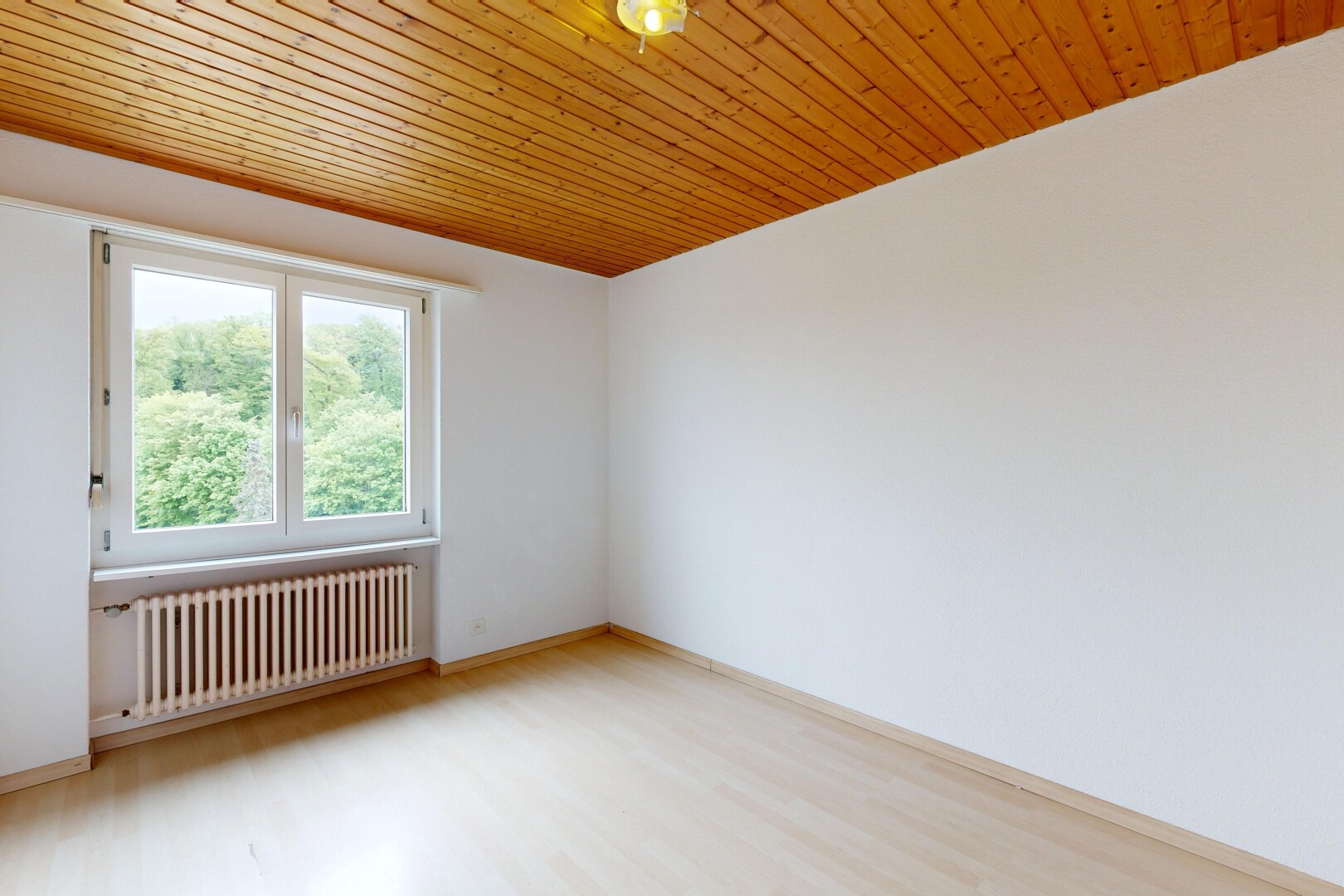 unfurnished room with radiator heating unit, light wood-type flooring, and wood ceiling