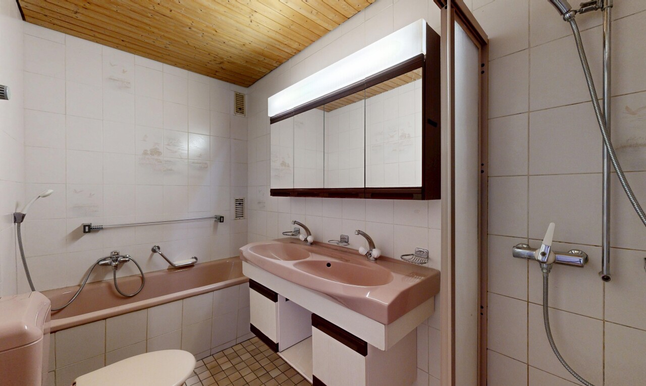 bathroom featuring tile walls, a tile shower, a garden tub, and double vanity