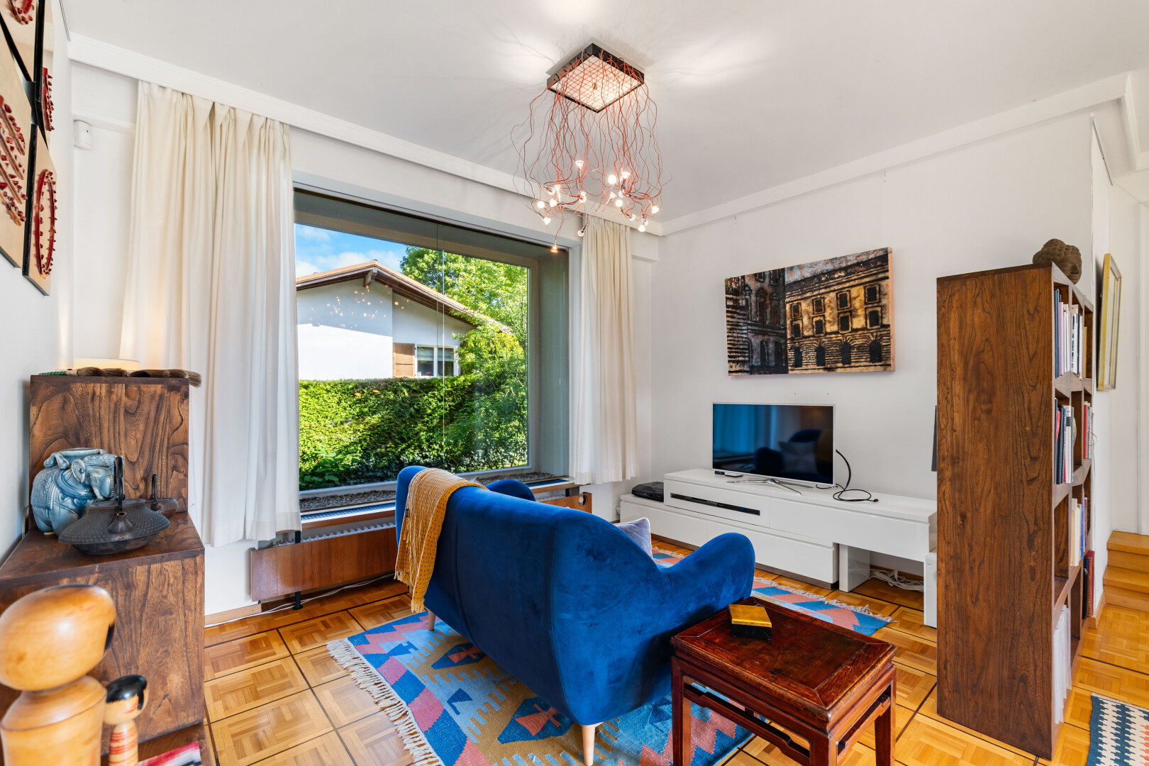 wohnzimmer mit bemerkenswerter kronleuchter, parquet floor, inside property, drywall, und gipskartonwand