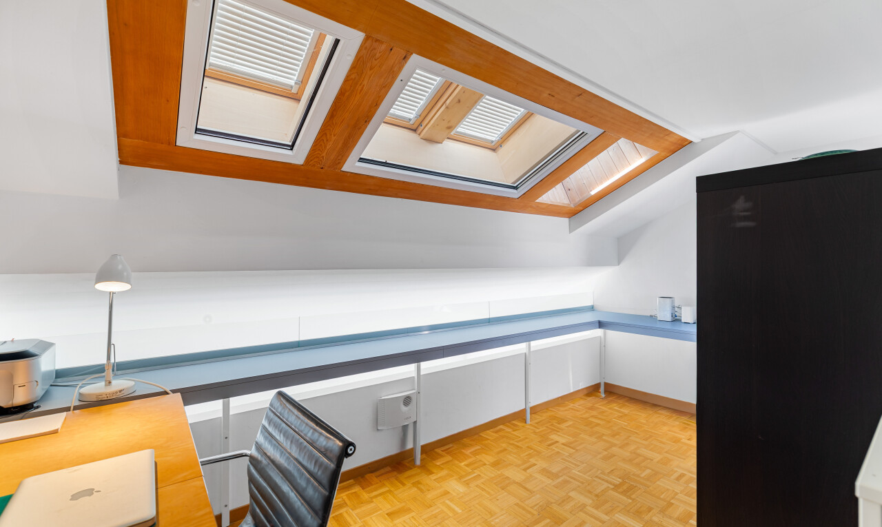 unfurnished room with an office area, parquet floors, vaulted ceiling, and a skylight
