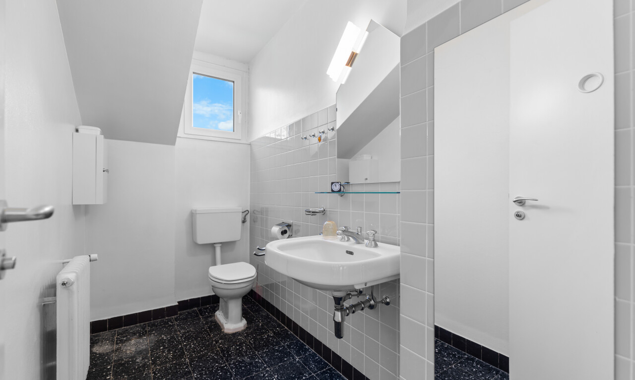salle de bains avec dark floor, tile wall, mur en carrelage, natural light, et lumière naturelle
