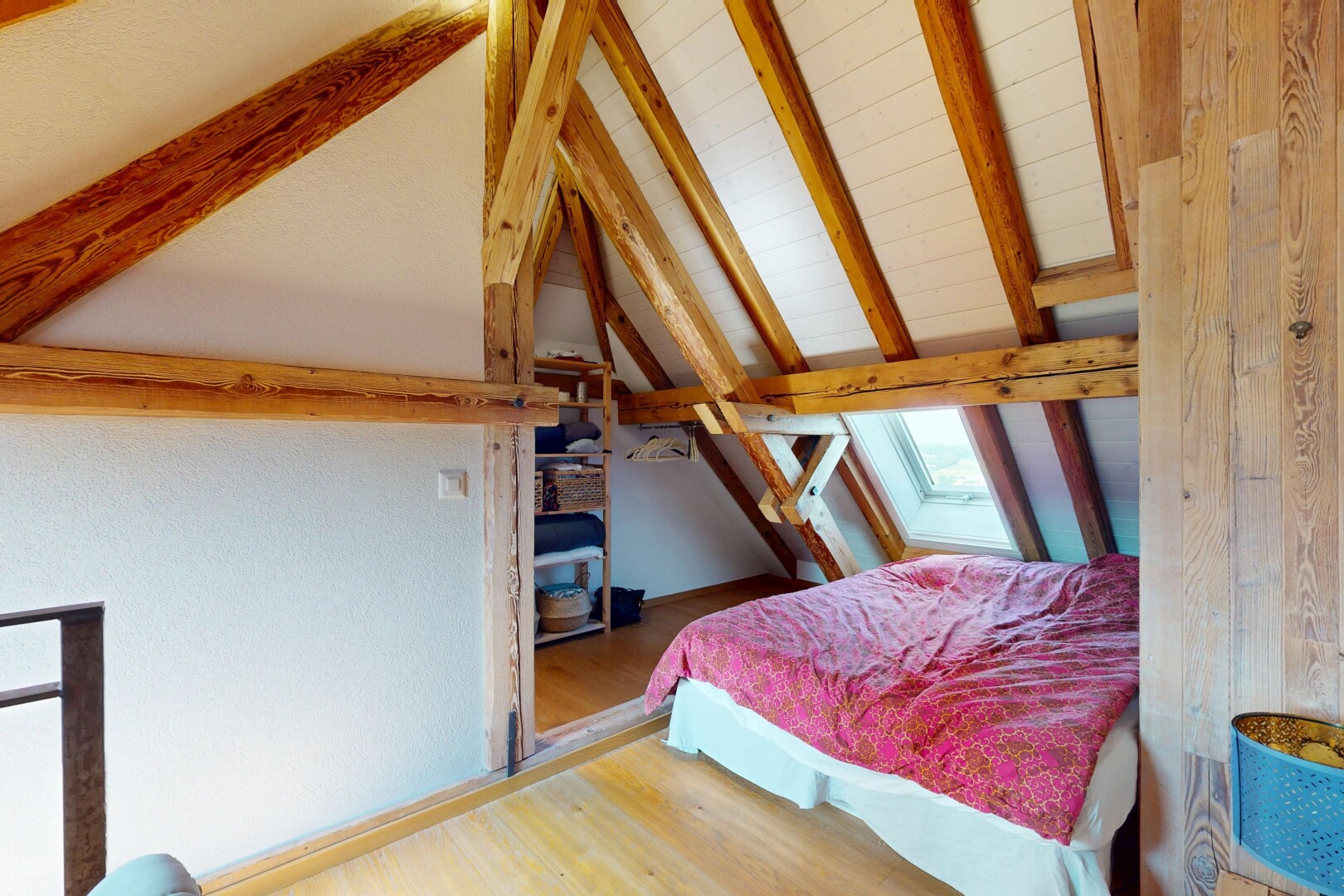 room / bedroom with wood finished floors and a skylight