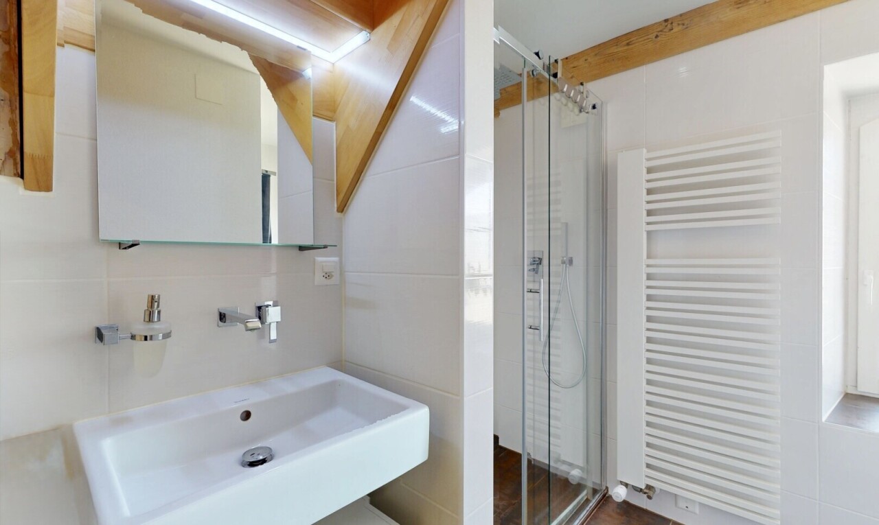 bathroom with radiator heating unit and a stall shower