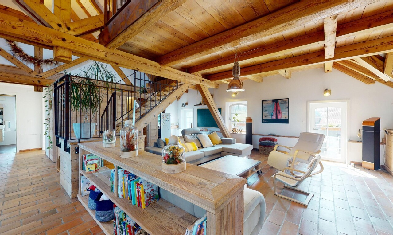 living room with stairway, healthy amount of natural light, and a wood ceiling with exposed beams
