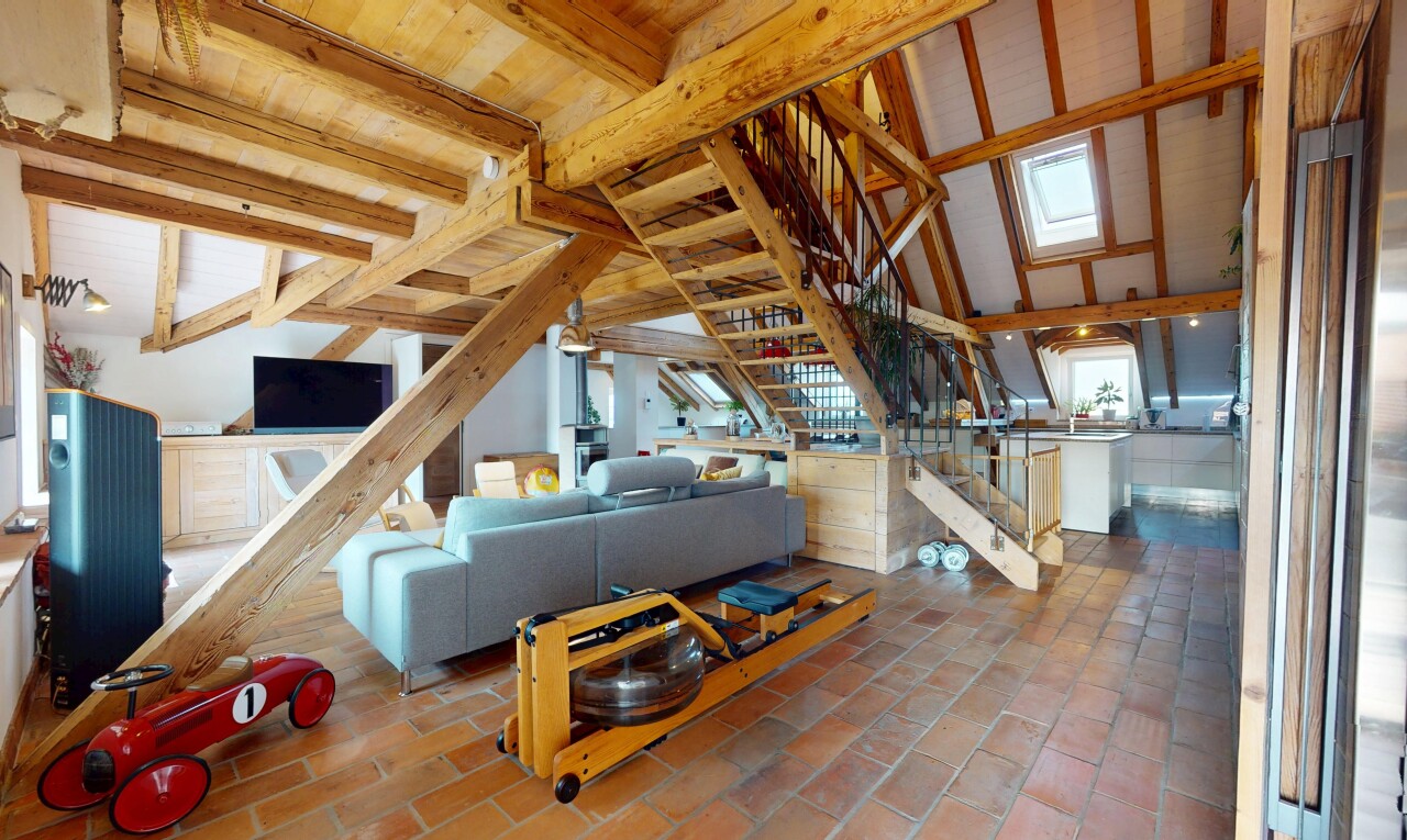 living room featuring stairway and beamed ceiling