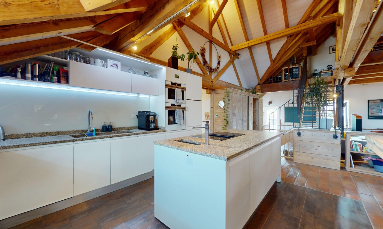 kitchen featuring white cabinetry, modern cabinets, high vaulted ceiling, a kitchen island with sink, and light stone countertops