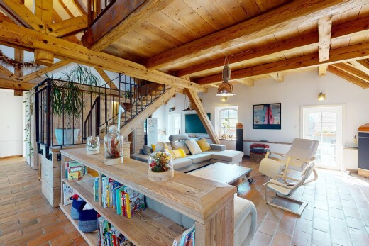 living room with stairway, healthy amount of natural light, and a wood ceiling with exposed beams