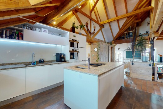 kitchen featuring white cabinetry, modern cabinets, high vaulted ceiling, a kitchen island with sink, and light stone countertops
