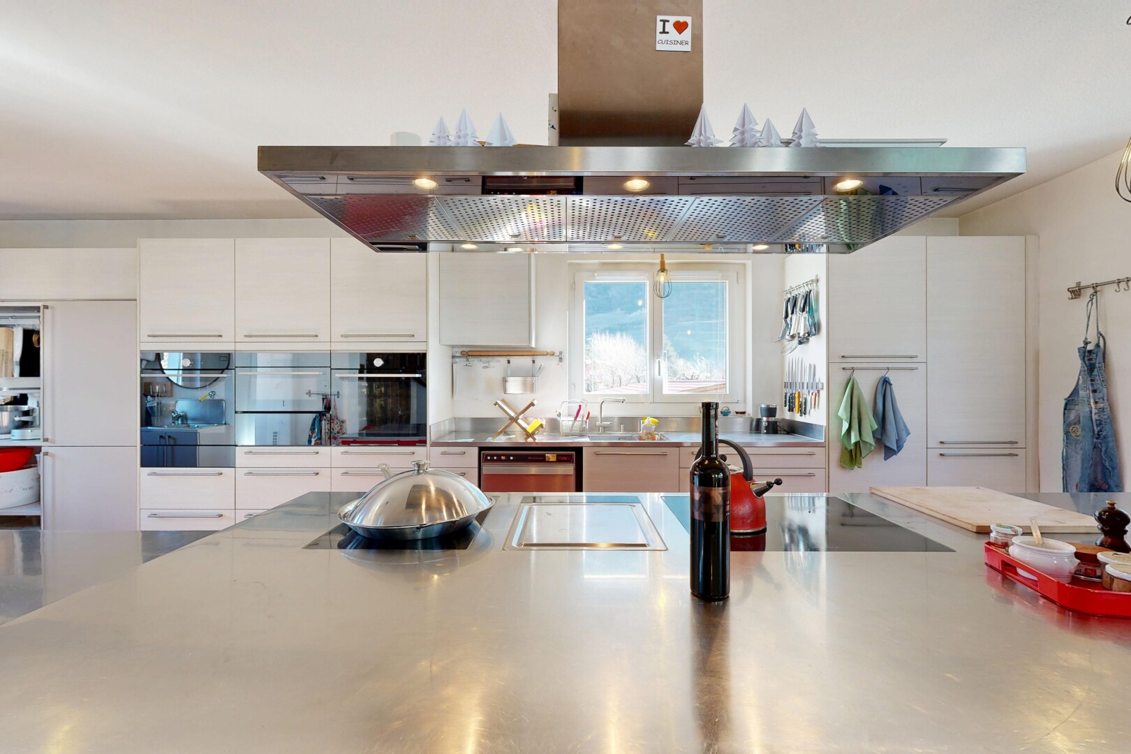 cuisine avec hotte, plans de travail en acier inoxydable, stainless steel countertops, light countertops, et inside property