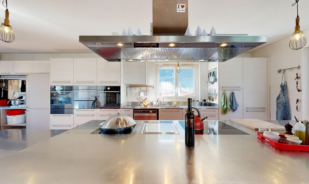 cuisine avec hotte, plans de travail en acier inoxydable, stainless steel countertops, light countertops, et inside property