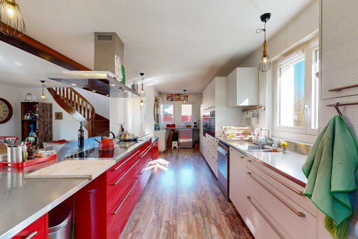 kitchen featuring decorative light fixtures, modern cabinets, range hood, dark wood-style floors, and stainless steel counters