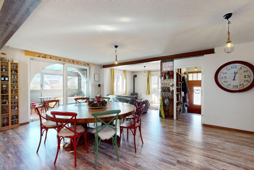 dining area featuring plenty of natural light, wood finished floors, and a wood stove