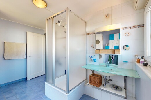 bathroom with a stall shower and baseboards