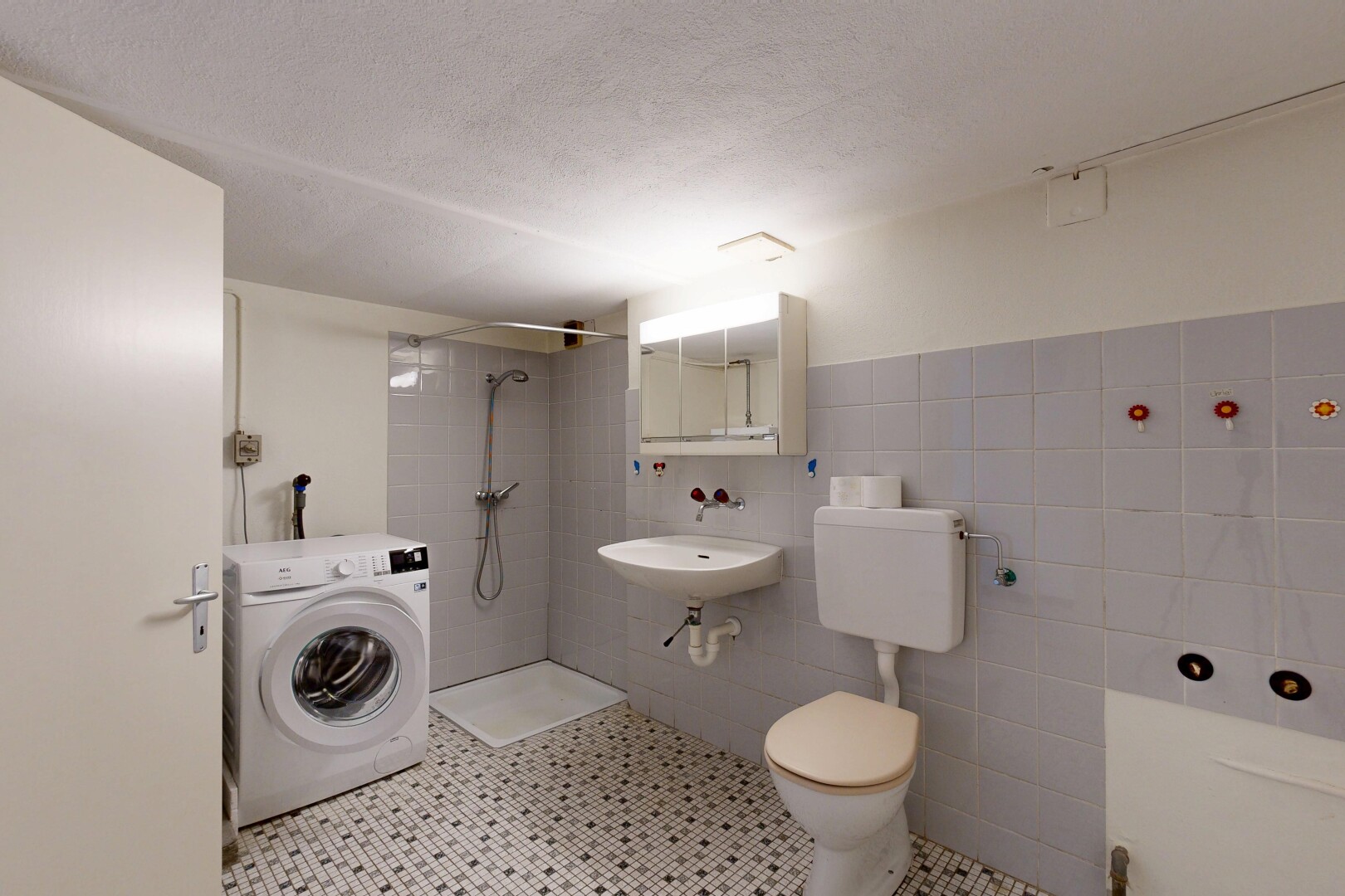 full bath featuring washer / clothes dryer, tiled shower, tile walls, light tile patterned floors, and a textured ceiling