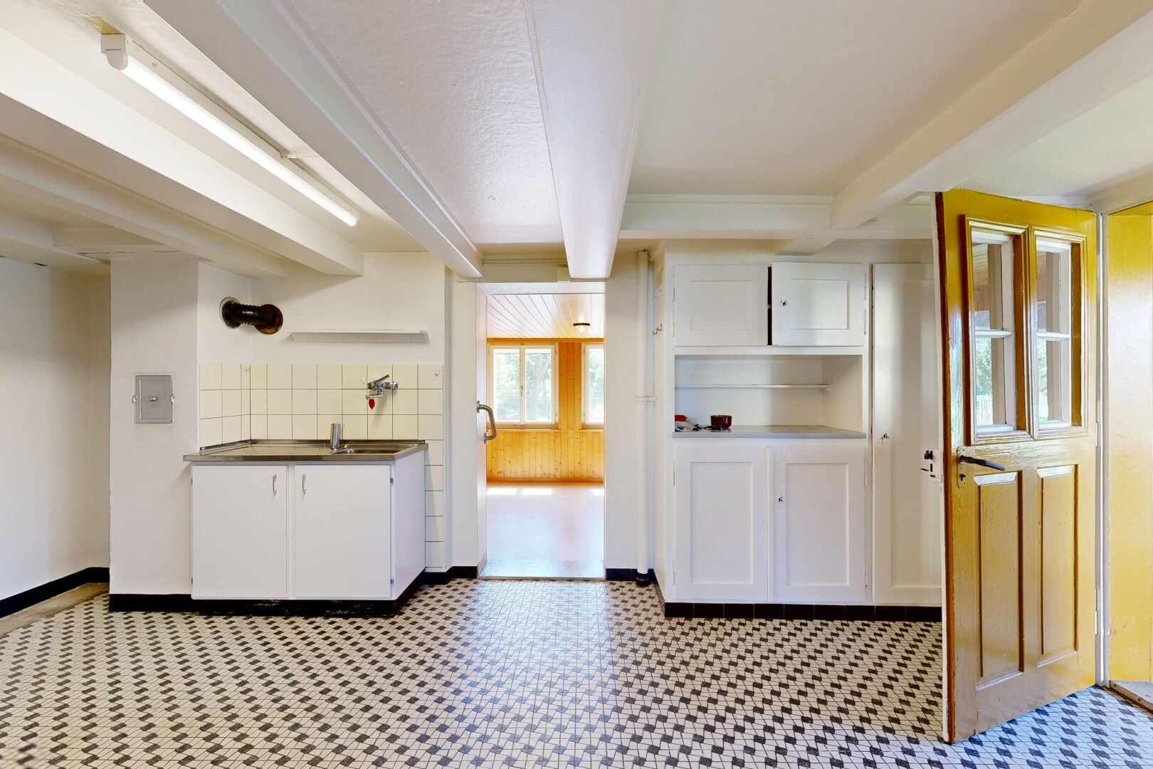 kitchen with white cabinetry, beamed ceiling, light flooring, open shelves, and dark countertops