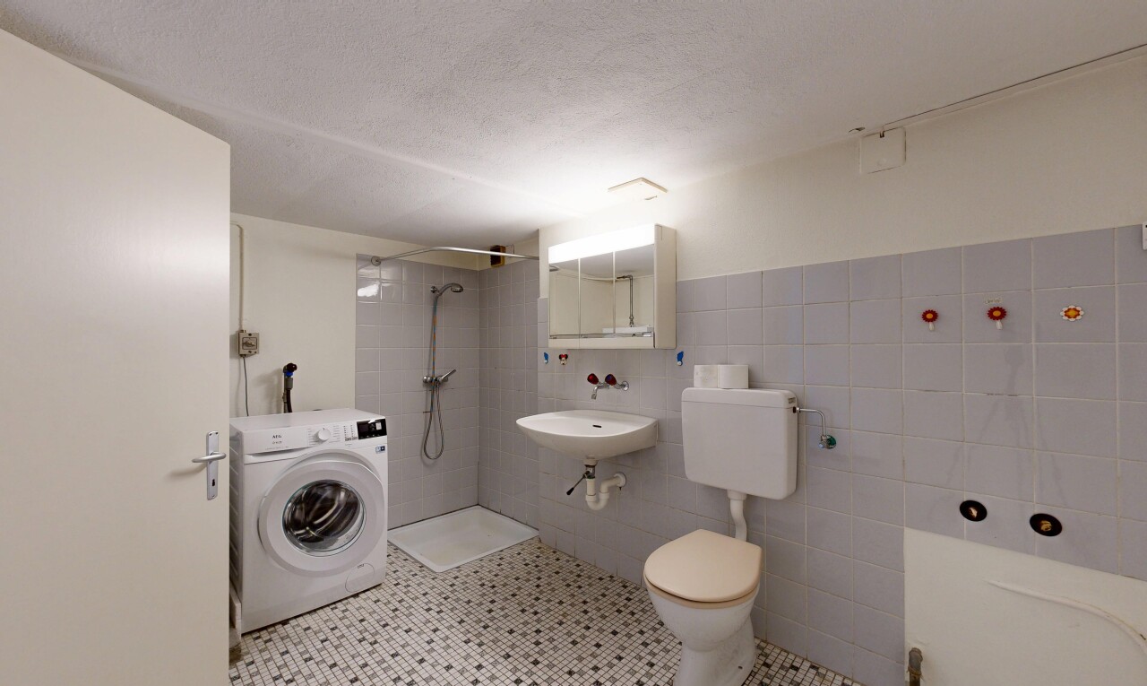 full bath featuring washer / clothes dryer, tiled shower, tile walls, light tile patterned floors, and a textured ceiling
