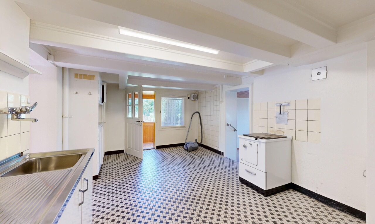 kitchen featuring white cabinets, dark floors, light countertops, and beamed ceiling