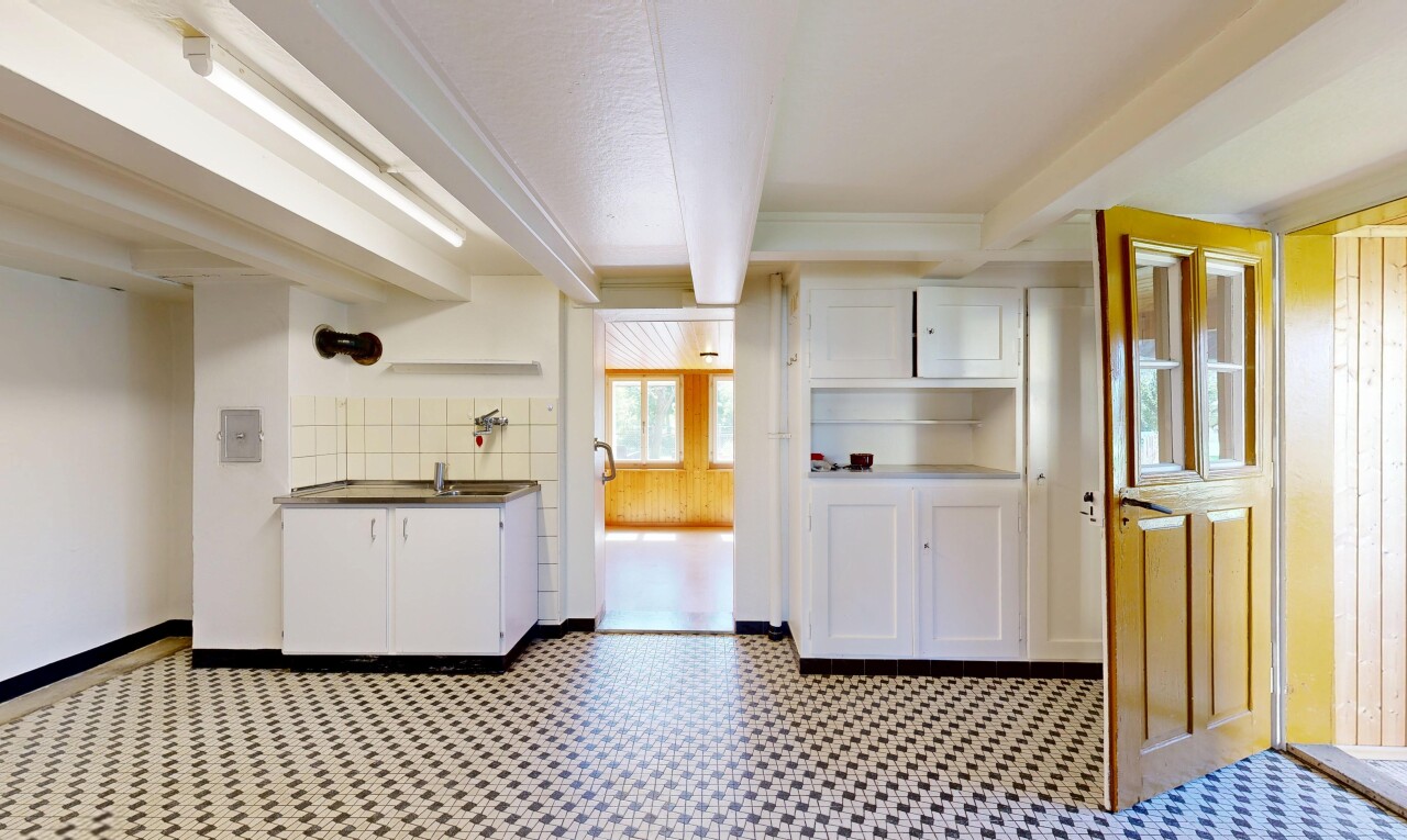 kitchen with white cabinetry, beamed ceiling, light flooring, open shelves, and dark countertops
