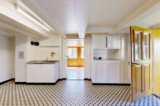 kitchen with white cabinetry, beamed ceiling, light flooring, open shelves, and dark countertops