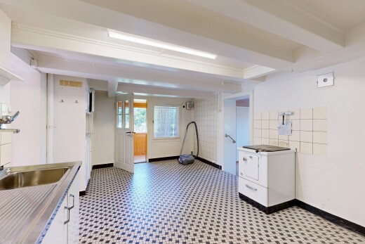 kitchen featuring white cabinets, dark floors, light countertops, and beamed ceiling