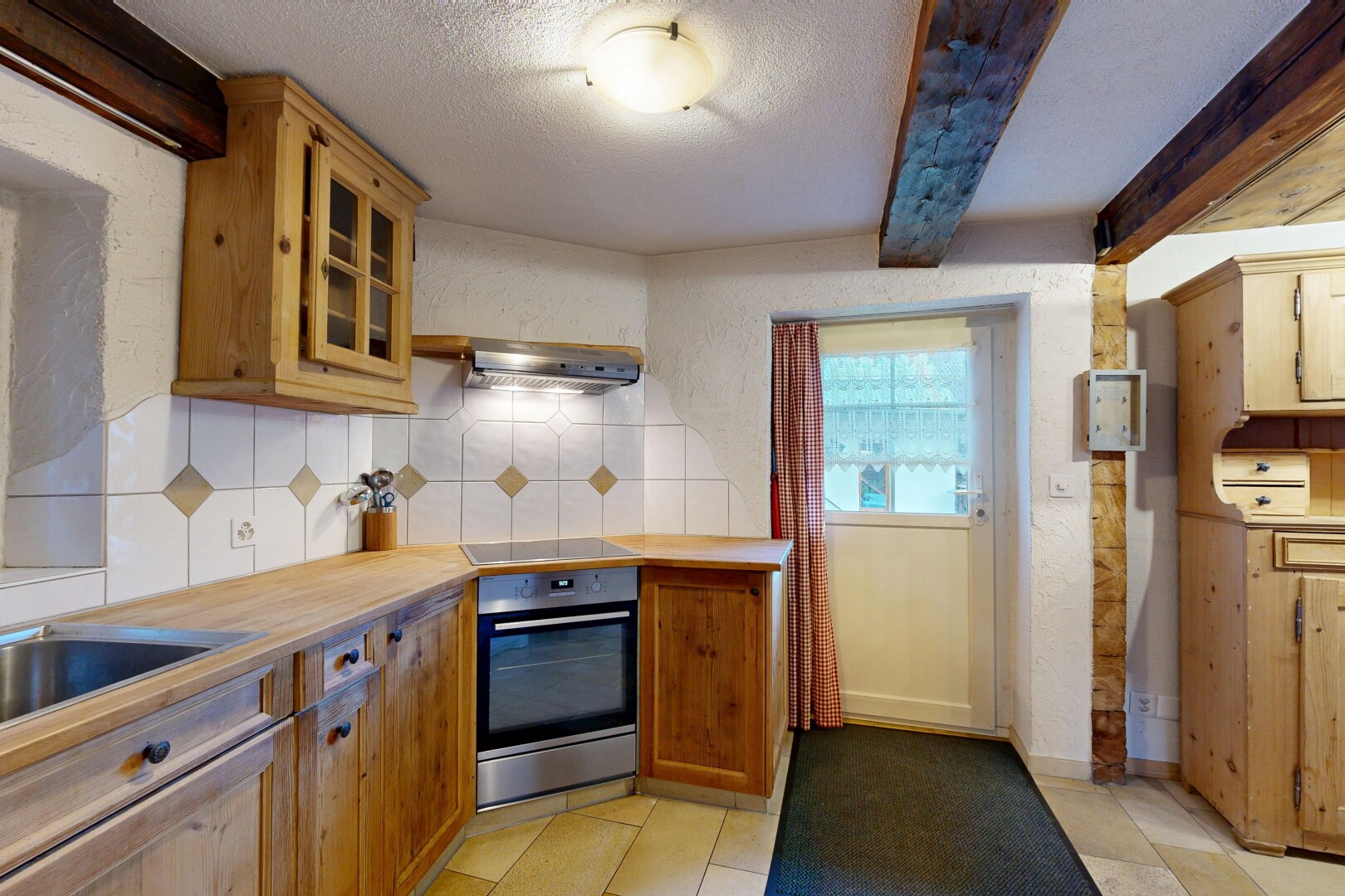 cuisine avec four, armoires avec moulures, dosseret, backsplash, et plafond texturé
