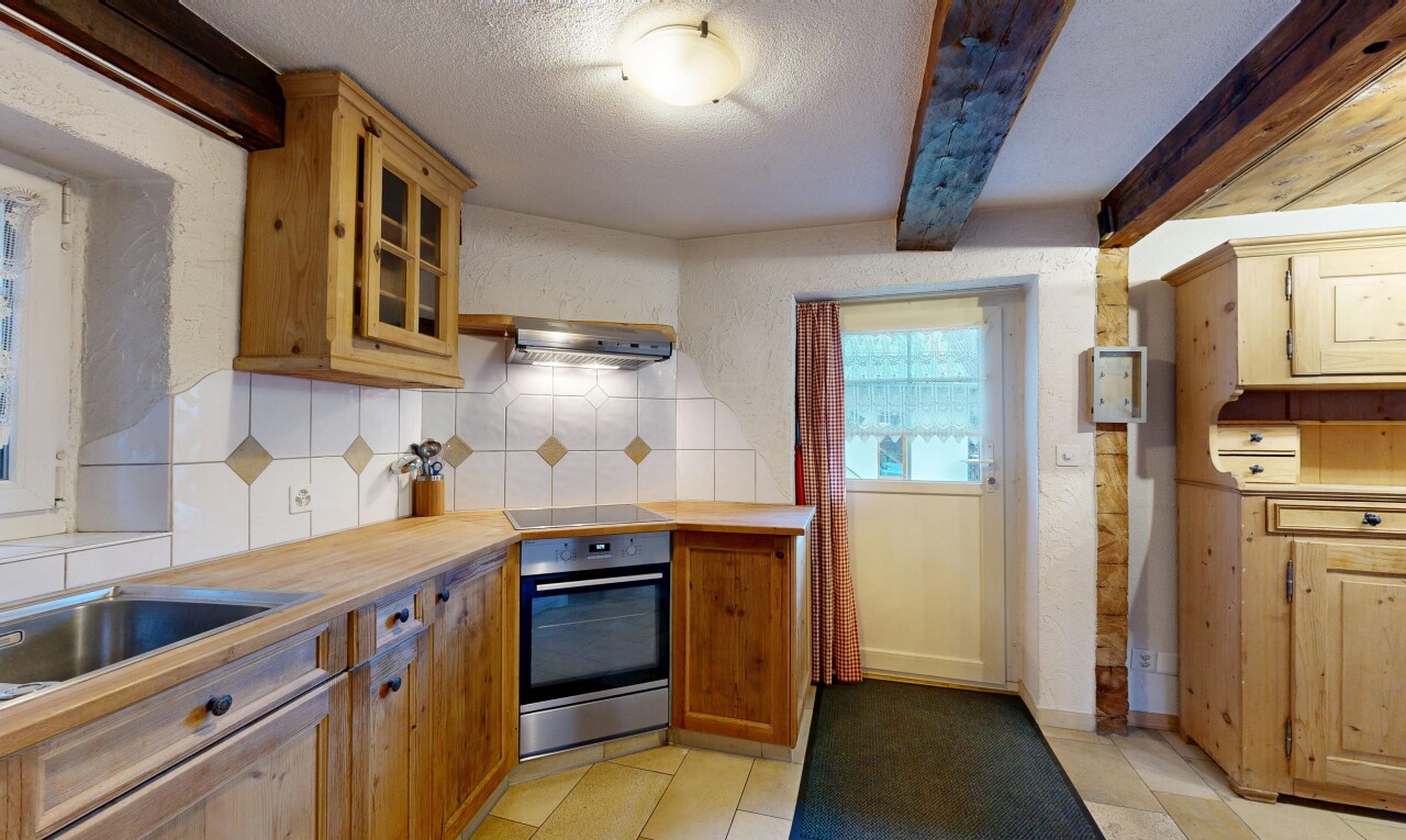 cuisine avec four, armoires avec moulures, dosseret, backsplash, et plafond texturé