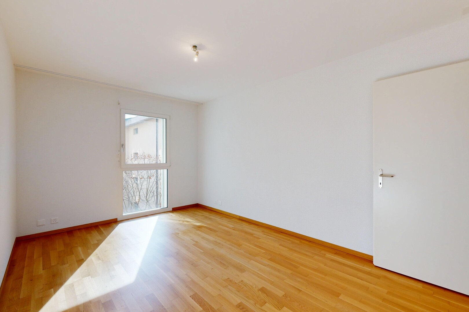 spare room featuring light wood-style floors and baseboards