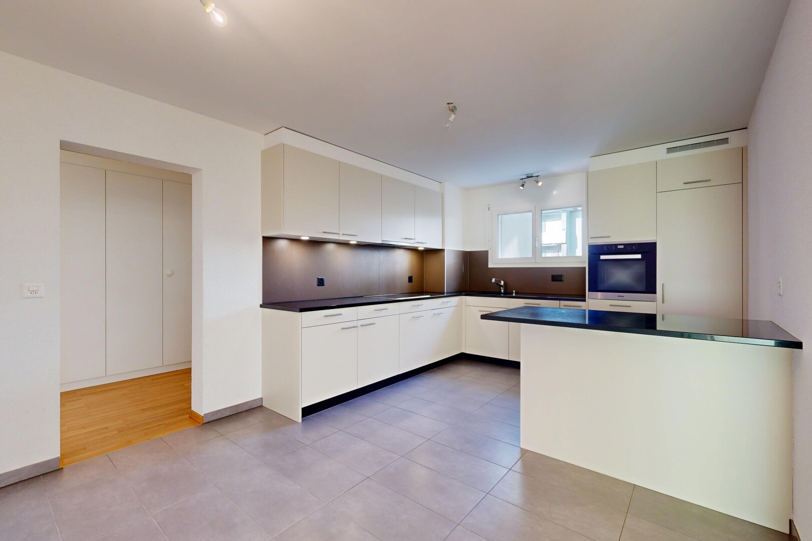 kitchen featuring light tile patterned floors, dark countertops, black oven, and modern cabinets