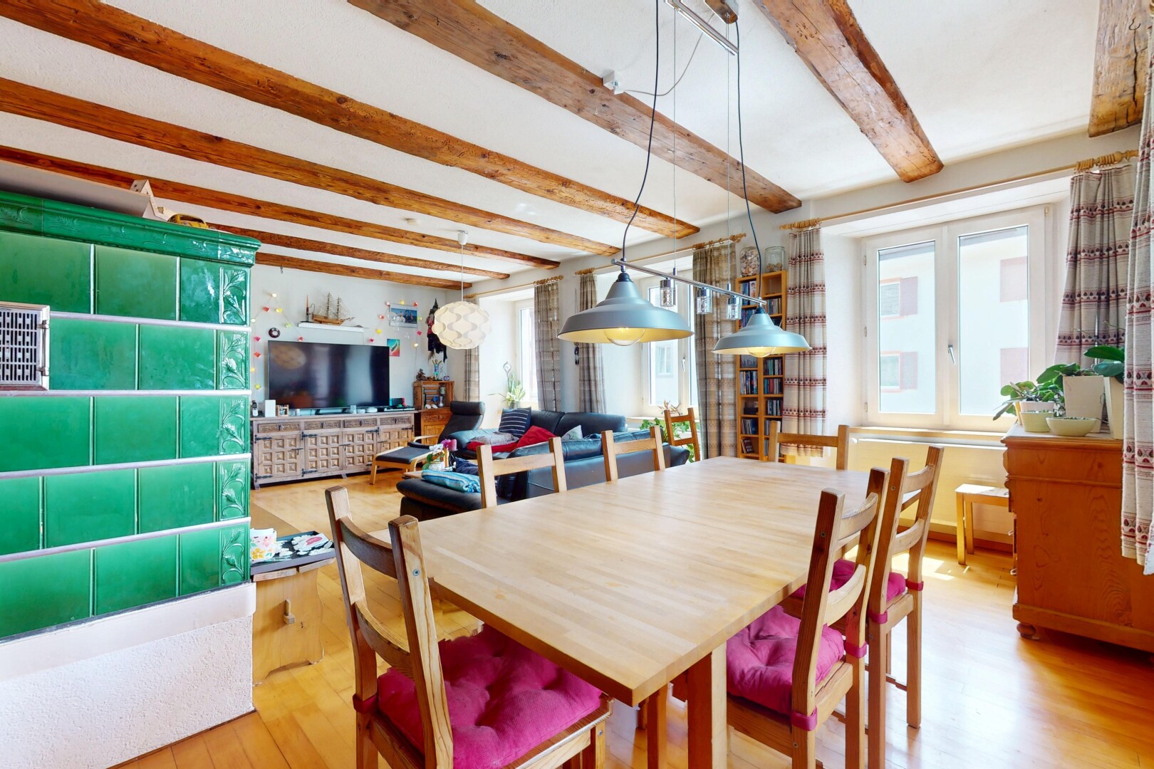 dining space with light wood finished floors and beam ceiling